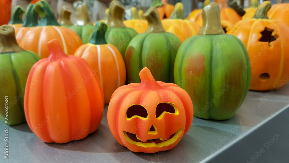 Group of hand painted colorful decoration clay pumpkins for Halloween on a grey table