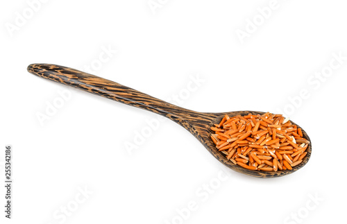 brown rice in wood spoon isolated on white background