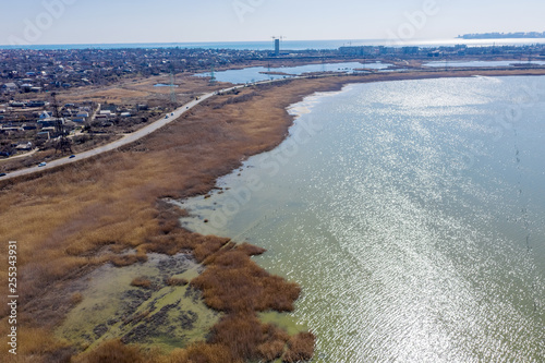 Top view of the coastal zone of the ecological reserve Kuyalnik estuary, Odessa, Ukraine. Aerial view from drone to sea estuaries in a suburban area near urban buildings © Aleksandr Lesik