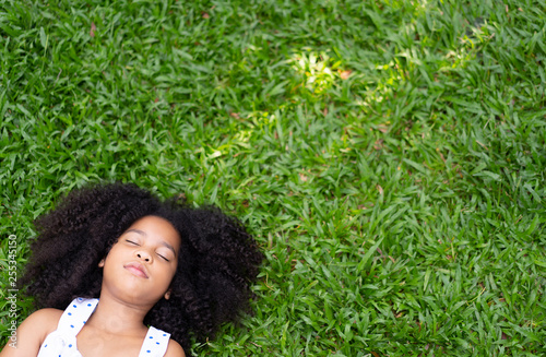 Top view of Child or little girl relax or sleeping or lying on grass on the grass in summer,rest one's eyes or During the lunch break with copy space for text your. freedom ,peace lifestyle concept