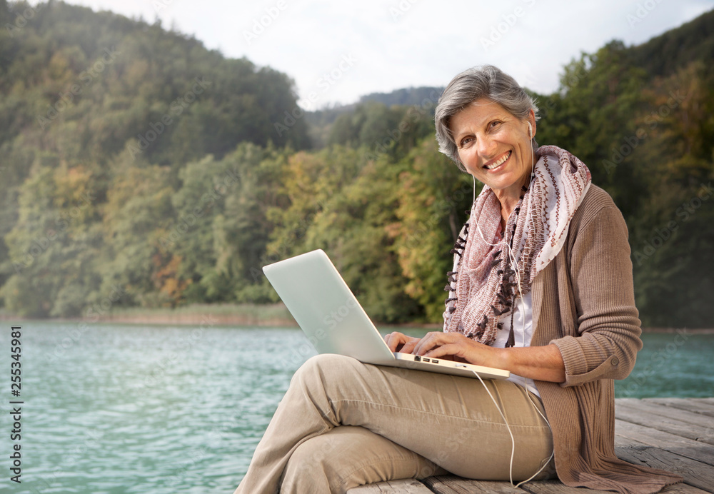 mature woman with laptop surfing the internet
