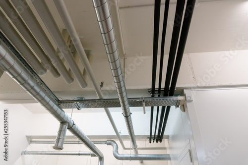 metal and plastic pipe system on the cellar ceiling of an apartment building photo