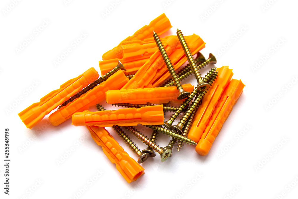A scattering of gold screws and orange dowels on a white background
