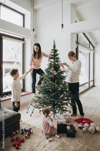 New Year. Decorate the Christmas tree. Artificial tree. A girl i