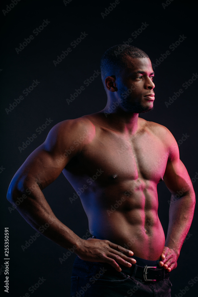 Muscular man African bodybuilder. Man posing on a black background, shows his health and perfect shape.