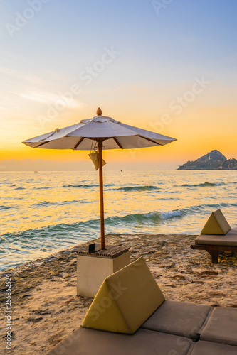 Umbrella and chair with pillow around beautiful landscape of beach and sea