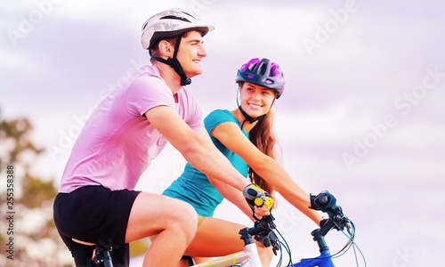 Fitness, sport, people and healthy lifestyle concept - happy couple riding bicycles outdoors at summer