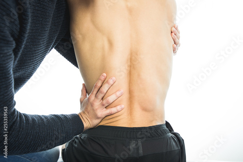 Physiotherapist examining a young man back. Physiotherapy concept