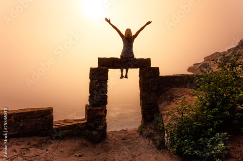 Female sits on top of doorway to the unknown realm photo