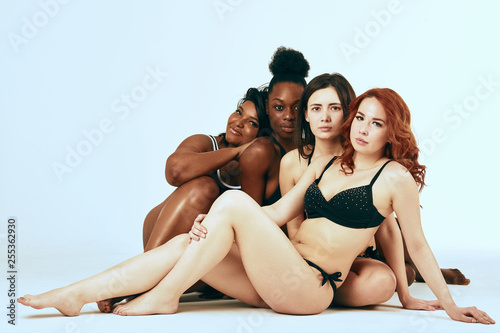 Multi-ethnic beauty. Different ethnicity women - Caucasian, African, Latin, Hispanic beautiful adult girlfriends posing in underwear isolated over white studio background.