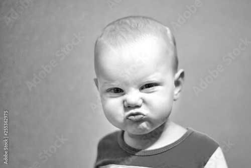 Portrait of a funny boy who grimaces, black and white photo