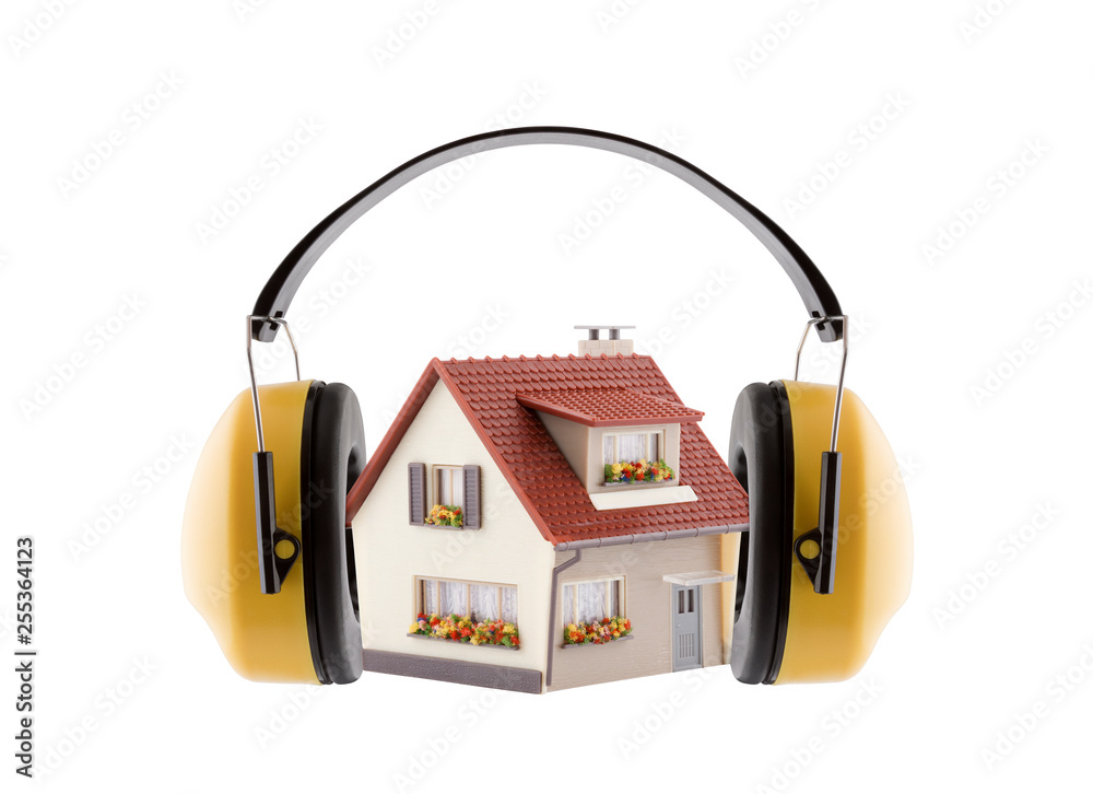 Protection against noise. Hearing protection yellow ear muffs with house miniature isolated on white background - obrazy, fototapety, plakaty 