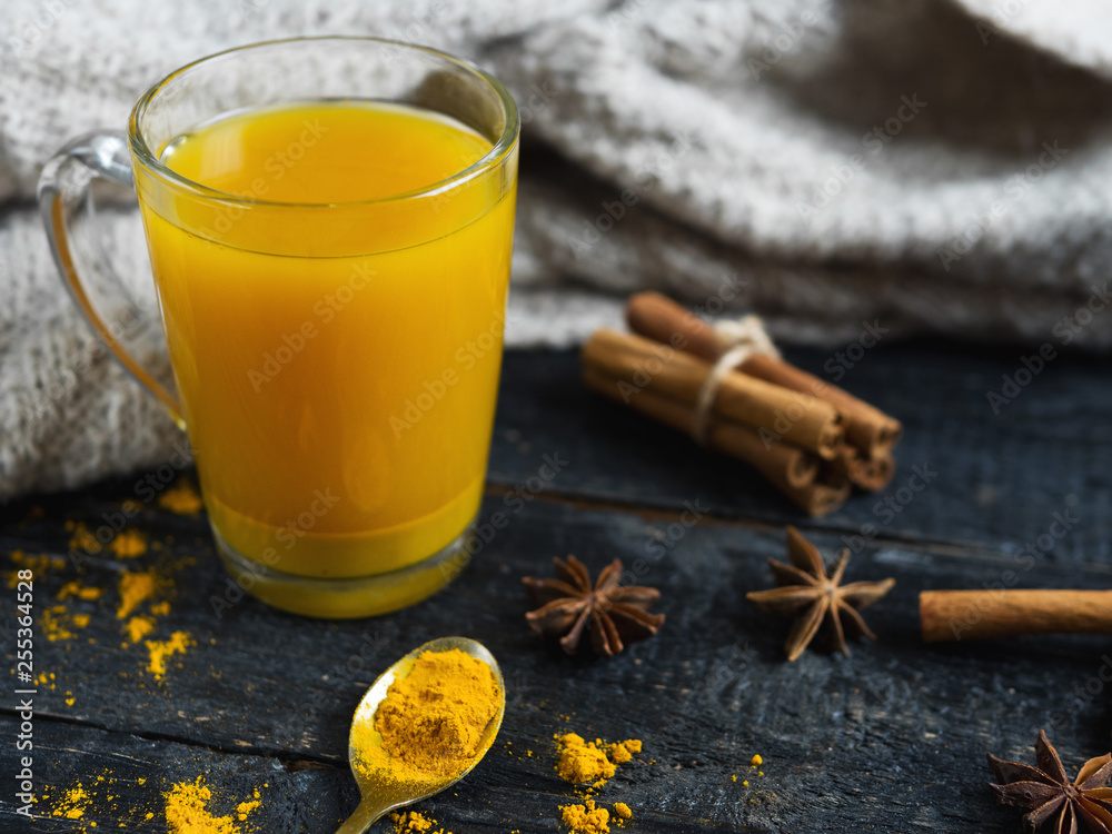 turmeric tea with cinnamon and ginger on wooden background turmeric tea with cinnamon and ginger on wooden background