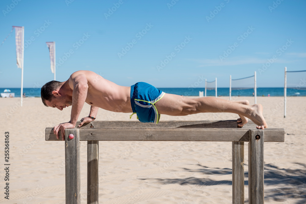 Fototapeta premium Attractive man doing sport on the beach