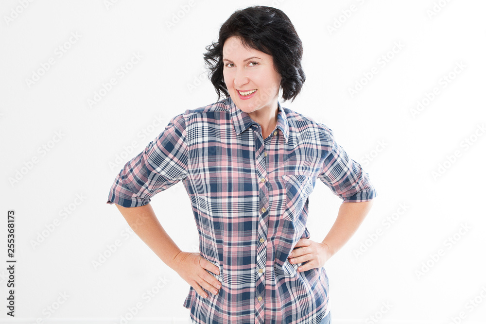 Portrait of older brunette woman smiling with arms crossed by white wall