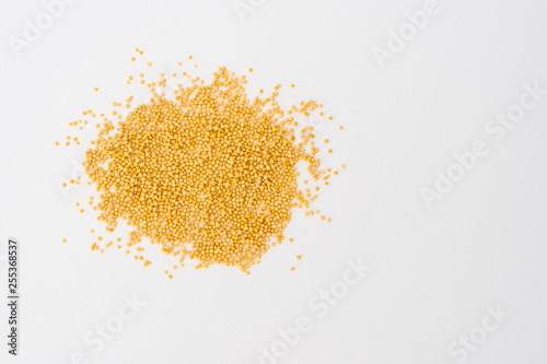 Yellow mustard seeds on white