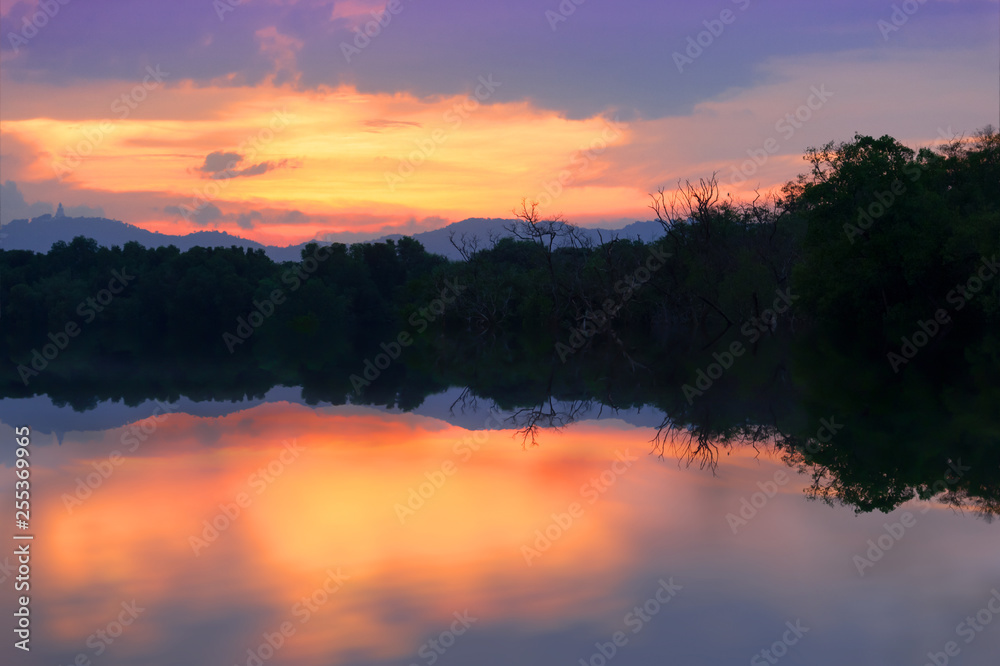 Colorful twilight sky..Silhouette swamp forest at twilight sky and water reflection..