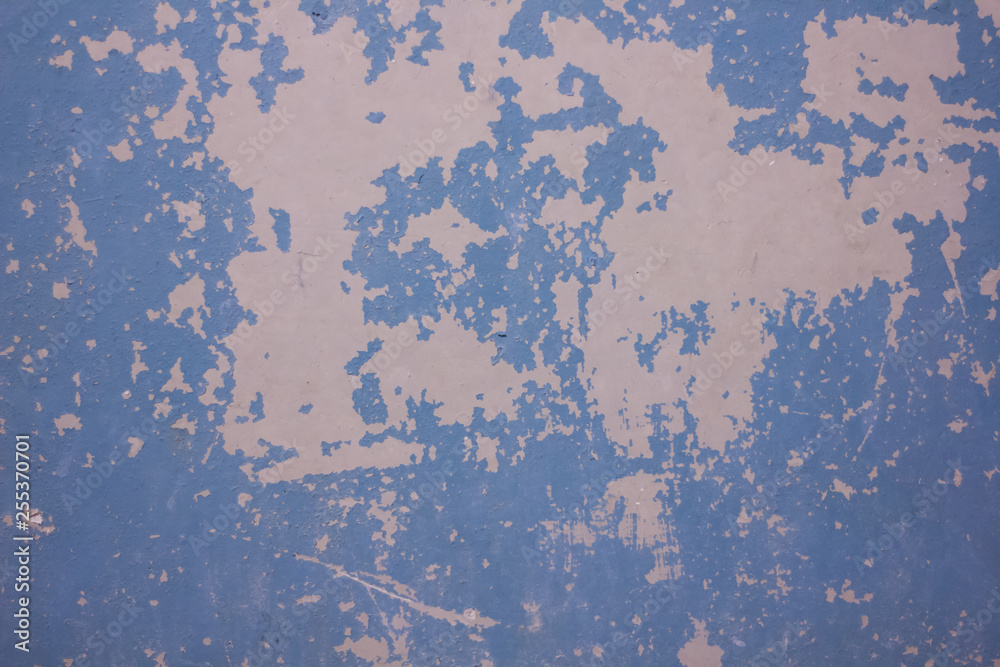 The texture of the wall with cracked blue paint. Cracked wall background