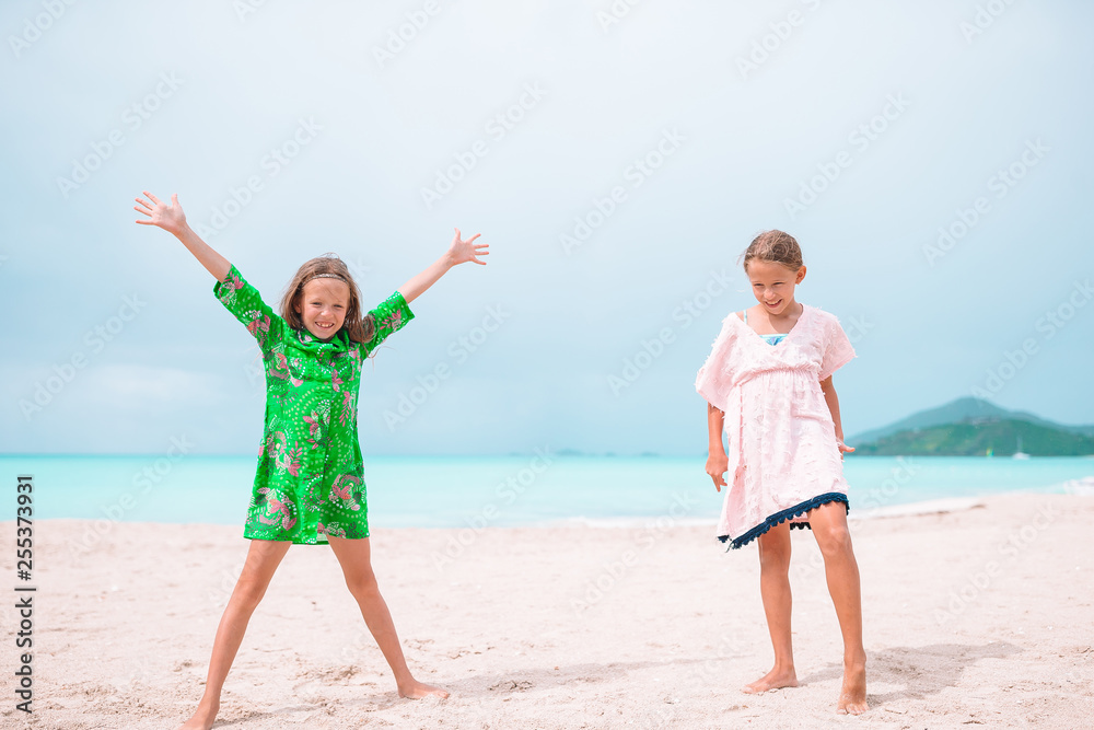 Little happy kids have a lot of fun at tropical beach playing together