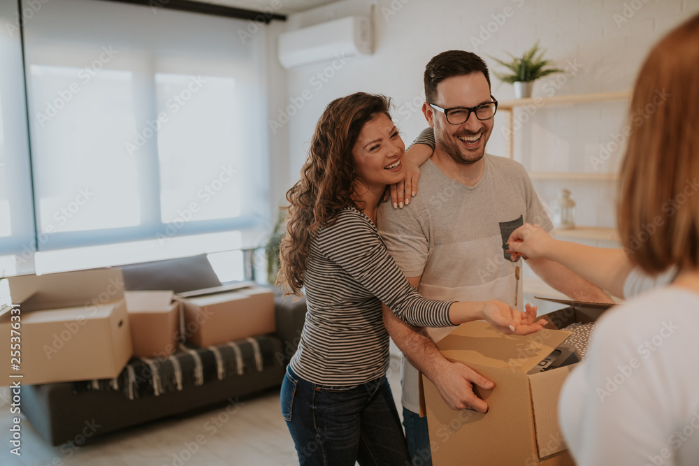 Happy married couple getting keys to their new house from female real estate agent. Happy married couple getting keys to their new house from female real estate agent.