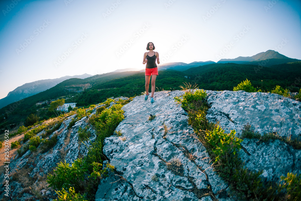 A girl is running in the mountains.