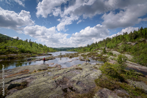 Girl hiker in red shirt standing in a beautiful lake landscape Norway