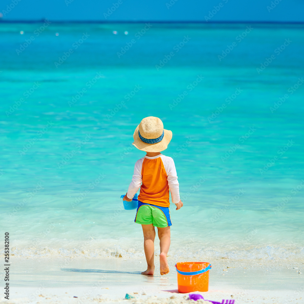 Three year old toddler playing on beach Three year old toddler playing on beach