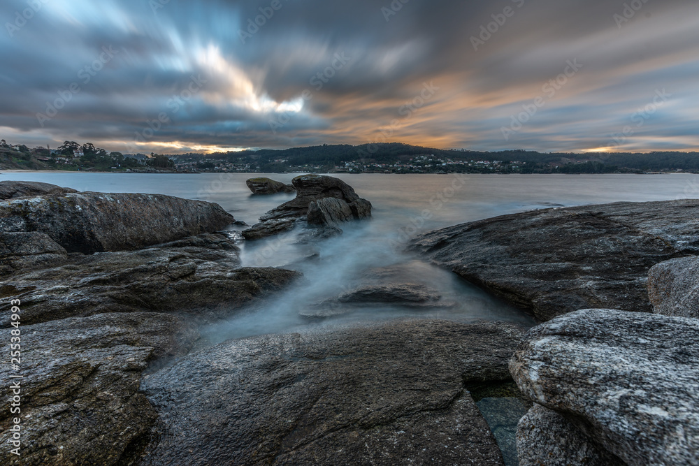 Paisaje de una playa rocosa con el cielo nublado en Cangas, Vigo, Pontevedra, Galicia, España. 