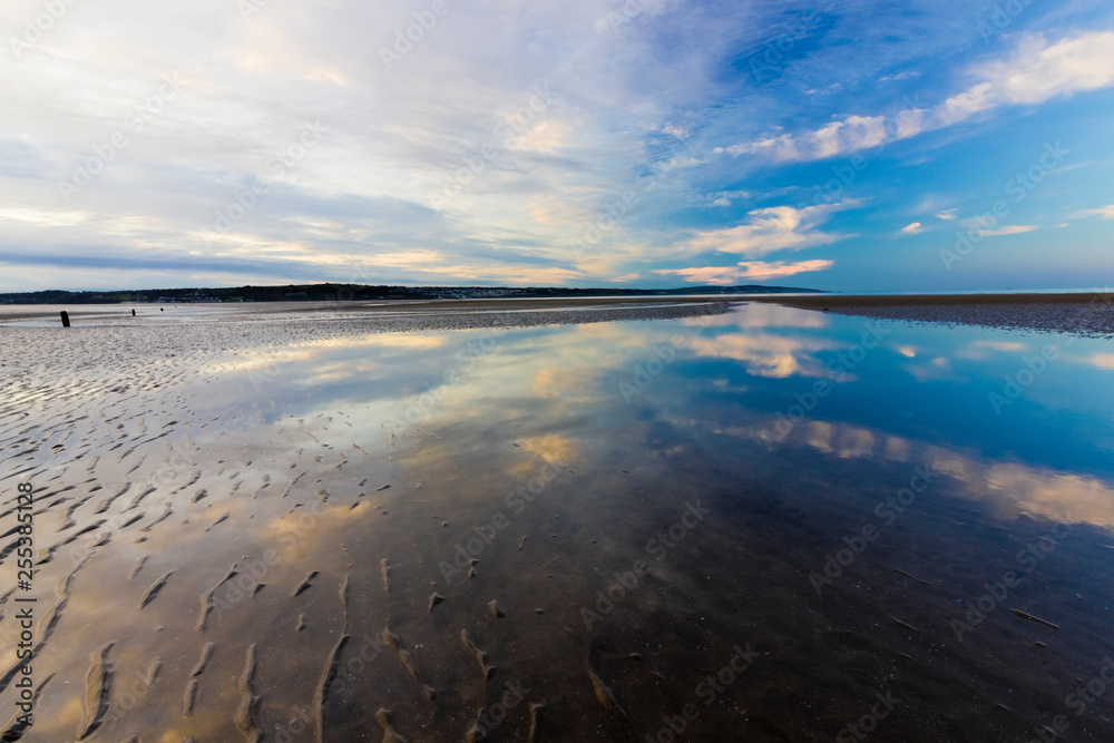 Stunning reflection of the twilight sky off the surface of the beach at Red Wharf Bay, Isle of Anglesey, North Wales