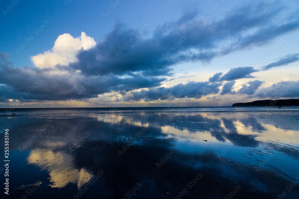 Threatening clouds reflecting off the surface of Red Wharf Bay, Anglesey, North Wales