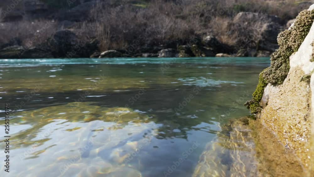 River with reflection of sunlight and stones under water River with reflection of sunlight and stones under water