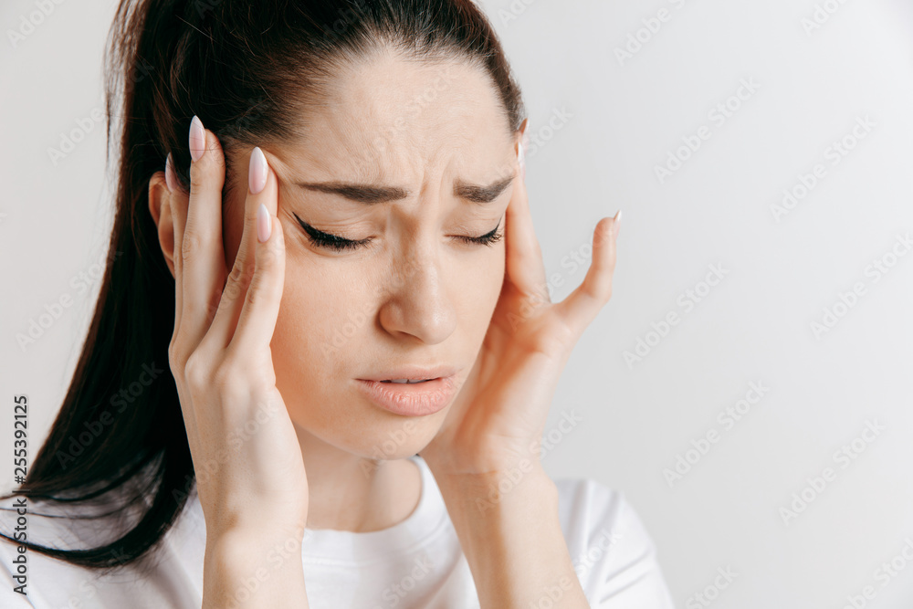 Woman having headache. Isolated on gray background. Businesswoman standing with pain isolated on gray background. Female half-length portrait. Human emotions, facial expression concept. Woman having headache. Isolated on gray background. Businesswoman standing with pain isolated on gray background. Female half-length portrait. Human emotions, facial expression concept.