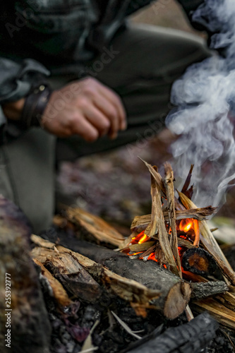Man lighting a fire in a forest