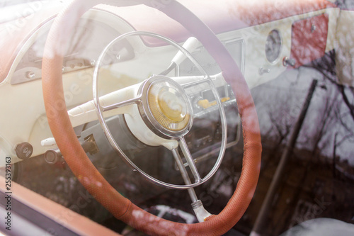 Interior view of old vintage car. Close-up steering wheel view through the glass