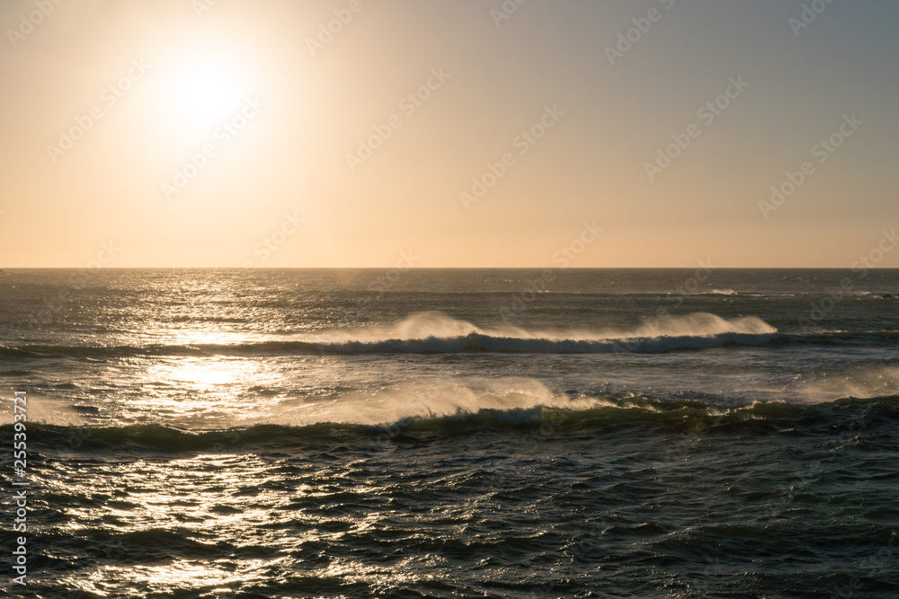 Picturesque sea waves near the rocky coast of Atlantic Ocean at Sunset time