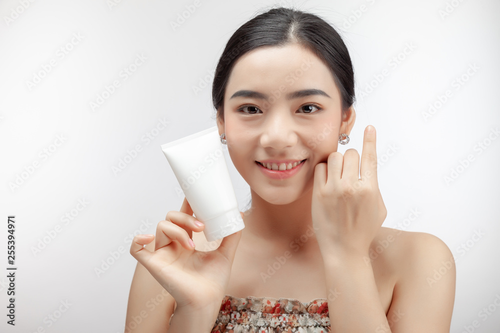 Young asian woman showing skincare products. mock up. Young asian woman showing skincare products. mock up.