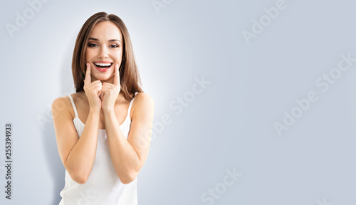 young woman showing smile, on grey