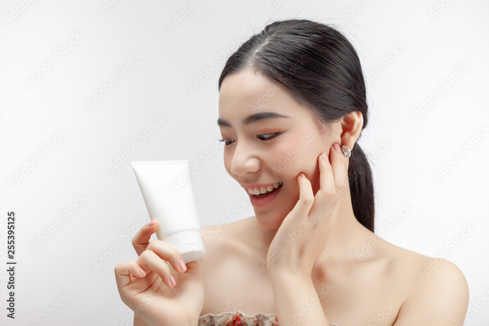 Young asian woman showing skincare products. mock up.