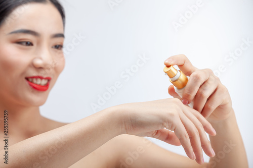 Young asian woman showing skincare products. Hand cream. mock up.