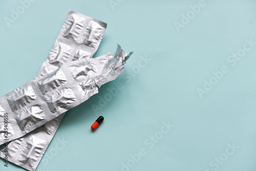 capsule pills in a blister pack, on a blue isolated background. The concept of global health. Antibiotics, drug resistance. Antimicrobial capsule tablets. Pharmaceutical Industry for Pain photo