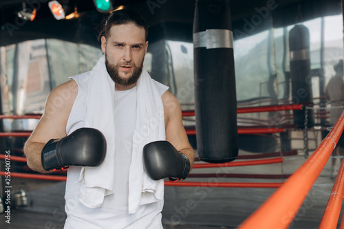 Boxer after training in the ring. Portrait of sweaty sportive boxer wearing boxing bandages