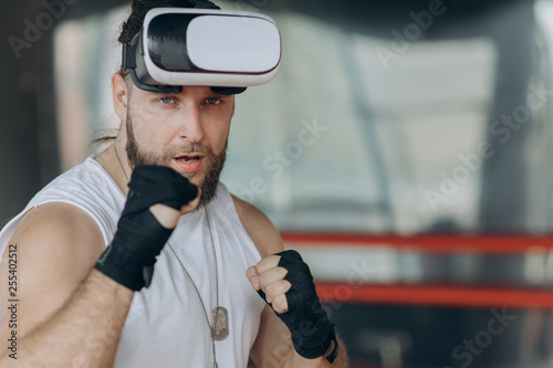 Man boxer in VR 360 headset training punches in virtual reality fight