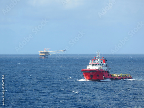 Supply boat support oil and gas industry. Supply boat transfer cargo to oil and gas industry and moving cargo from the boat to the platform. Boat is waiting transfer cargo and crews to platform. 