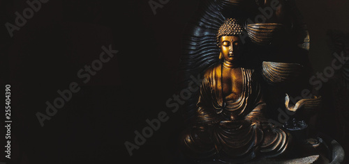 Golden Gautama Buddha statue with a black background. photo