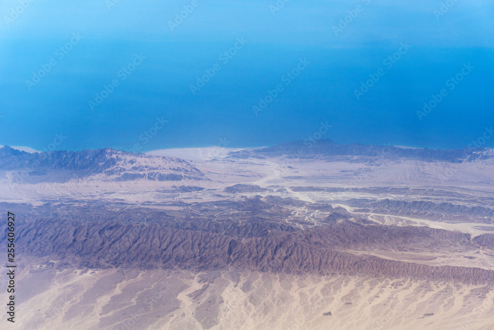 Blue sky over hilly terrain, aerial view