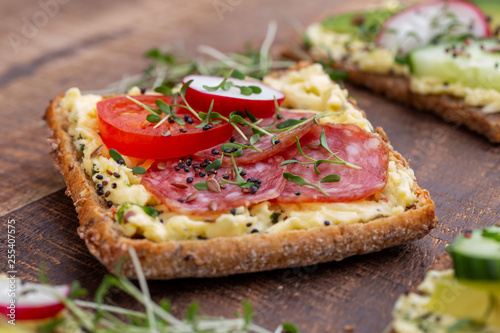 Sandwiches with cream cheese, vegetables and salami.