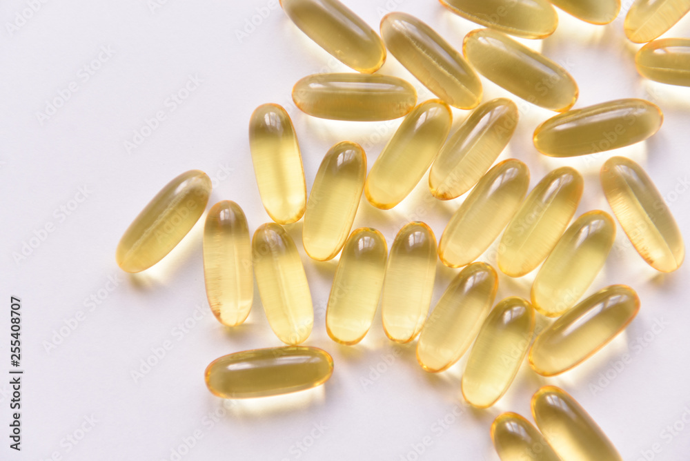 Fish oil capsules with omega 3 and vitamin D on a white background, isolated, healthy nutrition concept, close up shot. Fish oil capsules with omega 3 and vitamin D on a white background, isolated, healthy nutrition concept, close up shot.