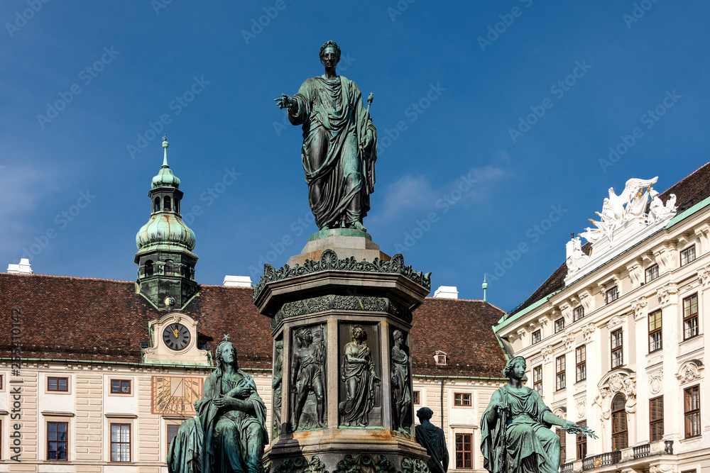 Fototapeta premium Austria, Vienna, Hofburg Palace, In der Burg: Famous emperor Francis statue and Austrian National Library facade at Josefsplatz in the city center of the capital with blue sky - concept Habsburg