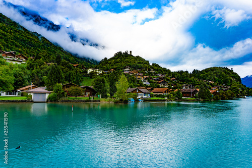 Natural landscape of clear blue lake with mountains and villages in cloudy day © Jphoto4956
