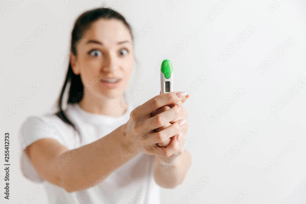 Smiling young woman looking on pregnancy test at studio. Smiling young woman looking on pregnancy test at studio.